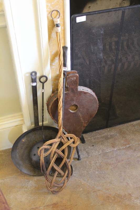 A wrought iron spark guard and other metalware, including a saucepan, ladle and sieve, a carpet