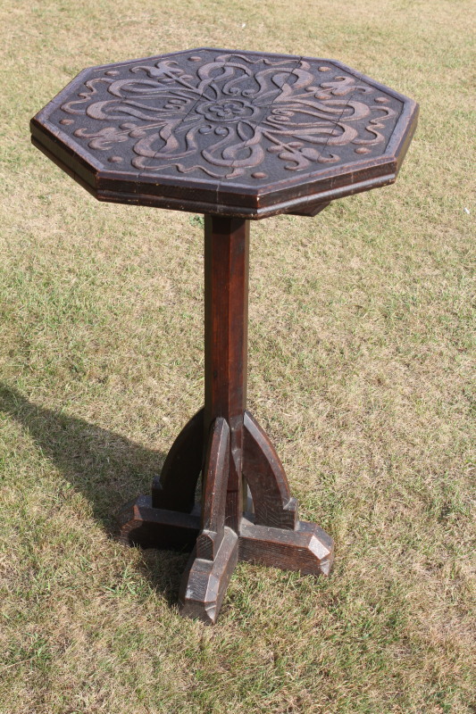 A 19thC Pugin style octagonal pedestal table with carved decoration to the top