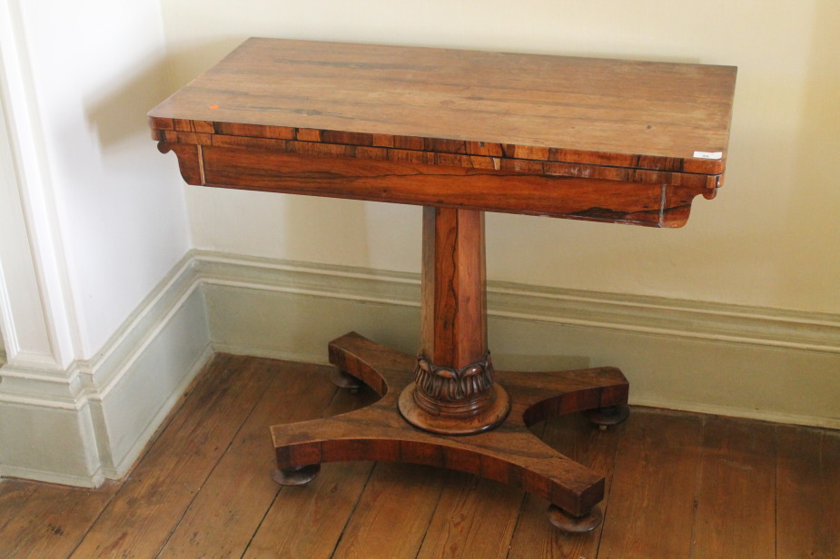 A Victorian rosewood card table with rectangular folding baize top, on taper octagonal pillar with