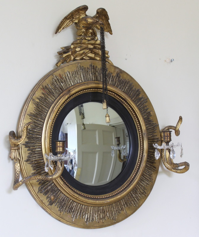 A Regency gilt framed convex girandole mirror, with eagle surmount and two serpent candle brackets