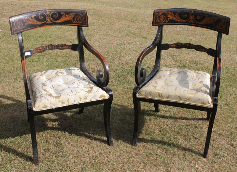 A pair of painted Regency period carver chairs, with overstuffed seat and sabre legs.