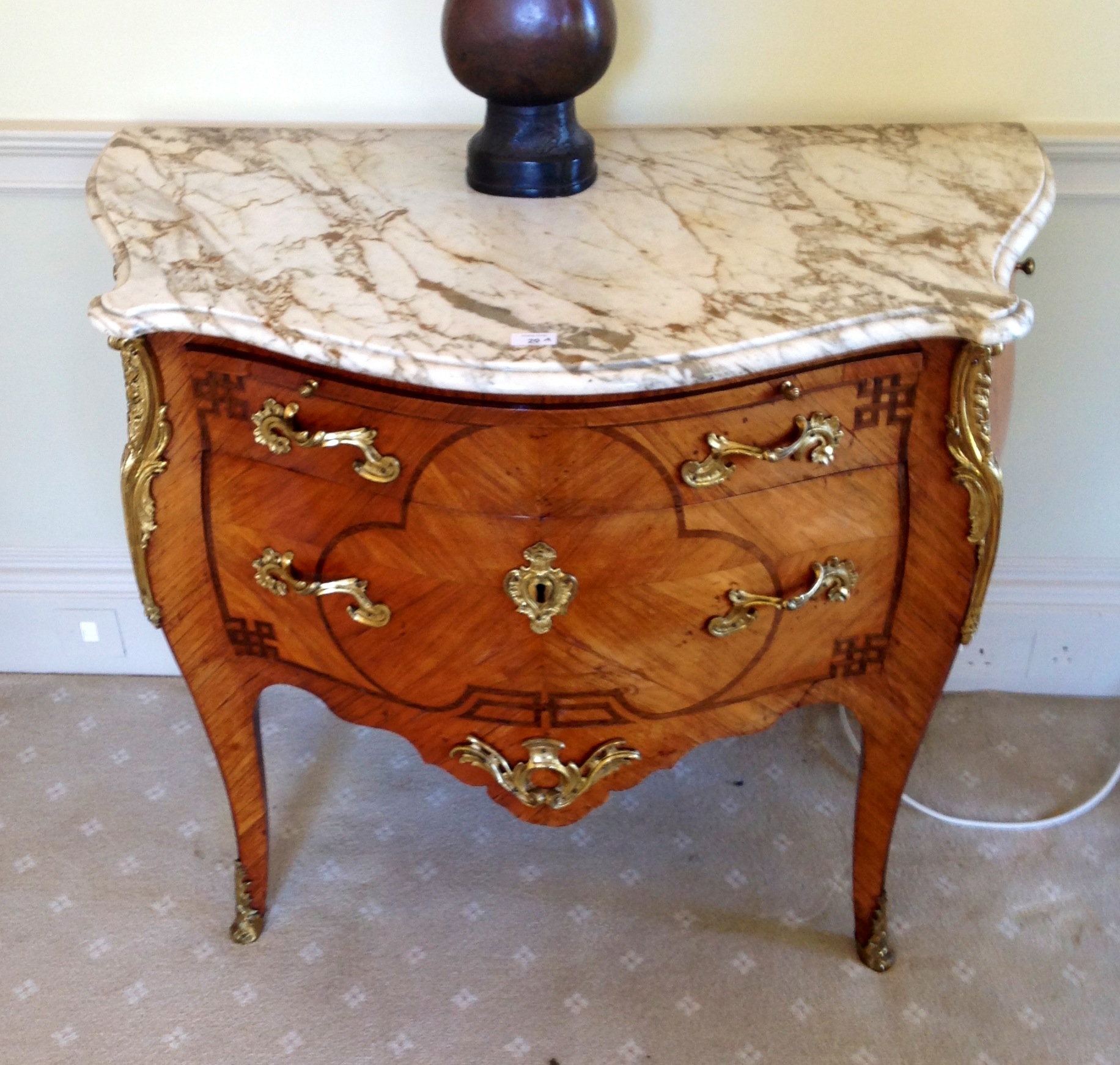 An 18thC French ormolu mounted tulip wood serpentine commode, with Kingwood veneers and cross