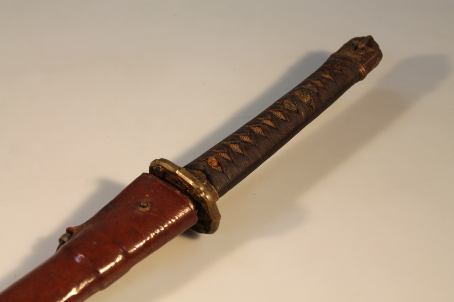 A 20thC Japanese Katana, with brass moulded tsuba and leather scabbard, 101cm overall.