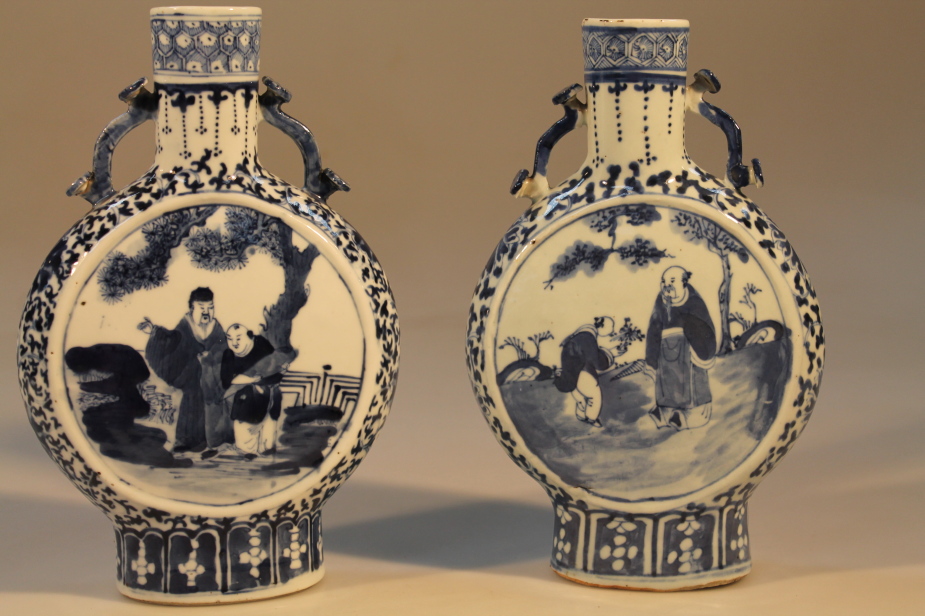 A pair of 19thC Chinese moon flasks, decorated in underglaze blue, the panels depicting a sage