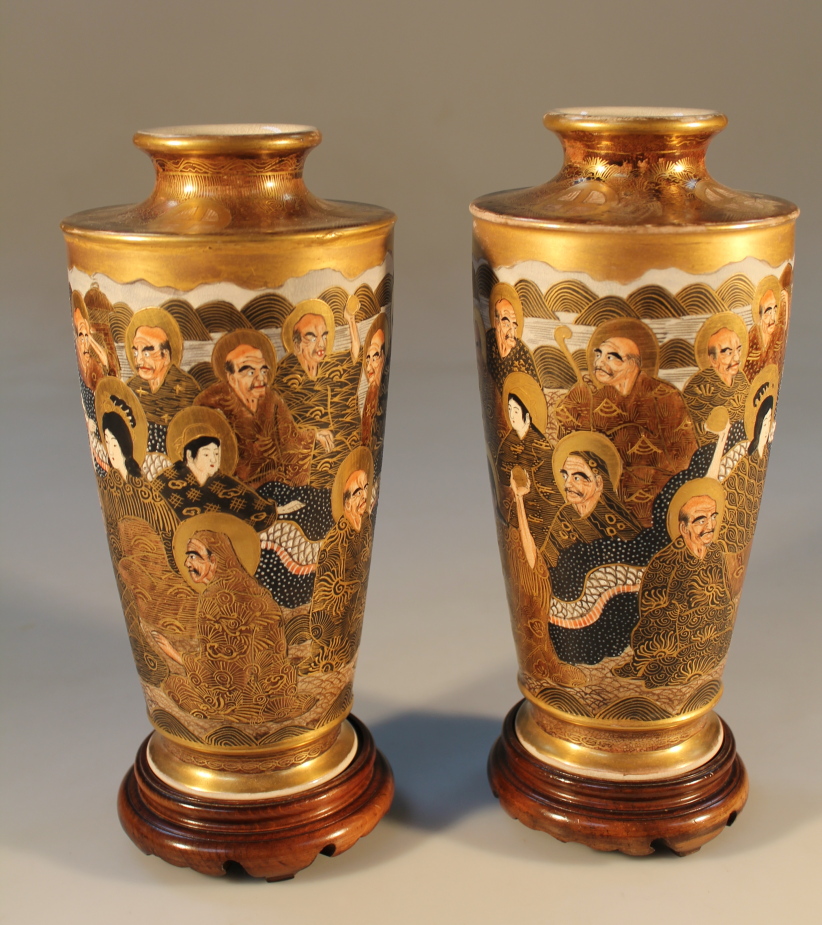 A pair of Japanese Satsuma cylindrical vases, decorated with sages and classical figures, on