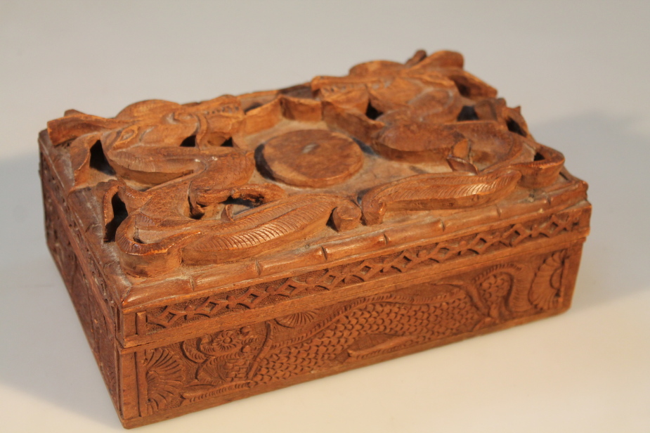 A 20thC Chinese cigarette box, the lid carved with two dragons, and carved dragons to side panels,