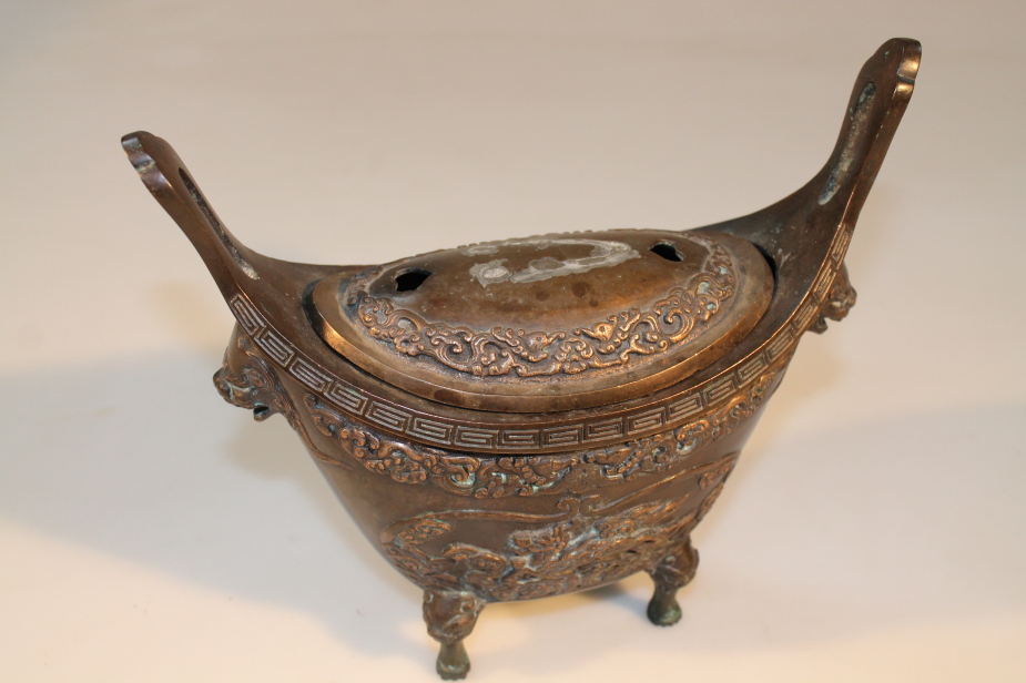 A Chinese bronze censer, of navette form, decorated in relief with a turtle and Kylin, with lion