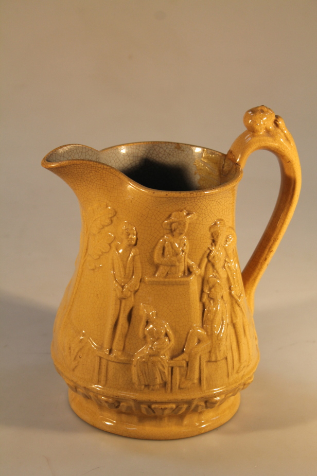 A 19thC Ridgeway slavery jug, moulded in relief depicting a slave auction and an overseer chasing