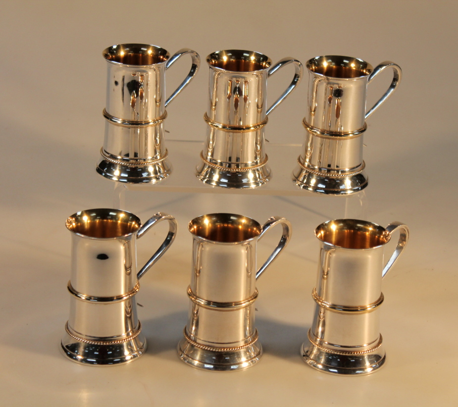 A set of six Elizabeth II silver cylindrical champagne cups, London 1988, 10cm high, 46.5oz.
