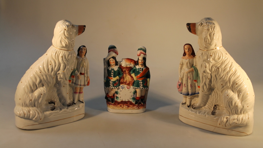 A matched pair of 19thC Staffordshire Spaniels with children, (AF), and another flat back figure,