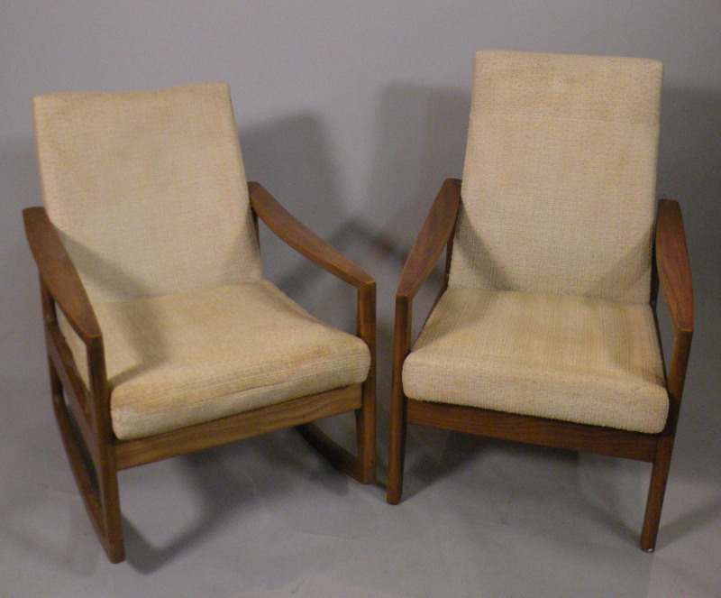 A pair of 1970`s rosewood armchairs, each with a padded back and loose cushions.  The upholstery