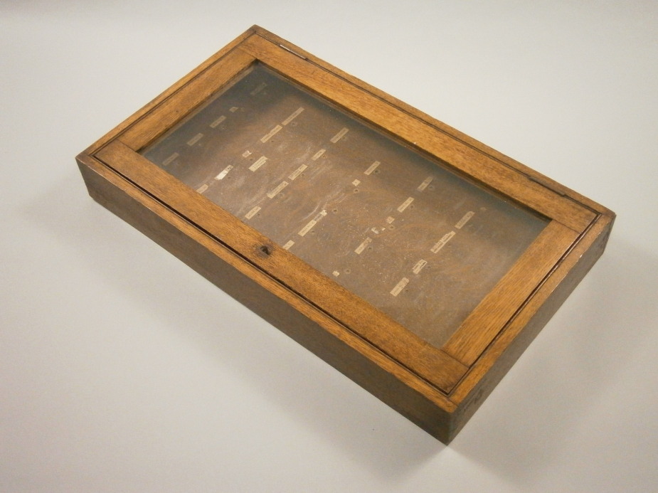 An oak glazed key cabinet, lacking hooks, 64cm x 37cm