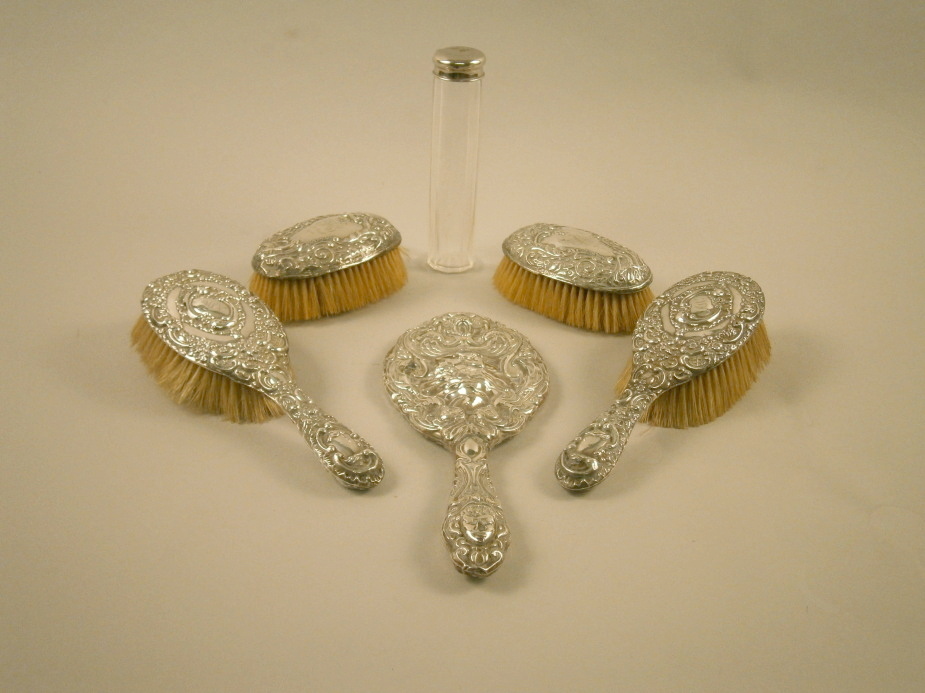 An associated silver mounted dressing table set, to include a hand mirror, two brushes with handles,