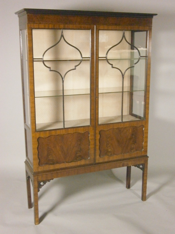 An Edwardian mahogany display cabinet, with two glazed doors each with inset panels, on square