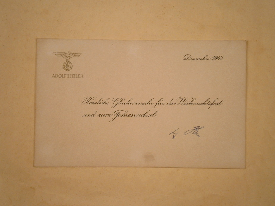 A Christmas greeting note signed by Adolf Hitler, with printed message, his emblem and bearing the
