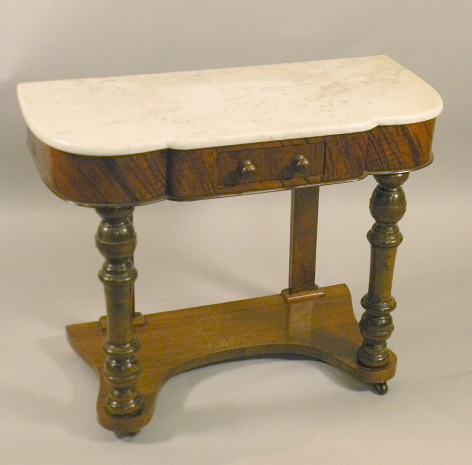 A Victorian walnut washstand, the white marble top with a shaped border, with a frieze drawer on