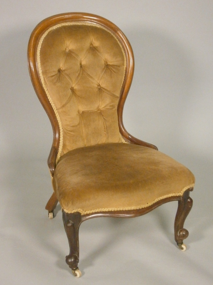 A Victorian mahogany show frame nursing chair, with a padded back and seat on cabriole legs.
