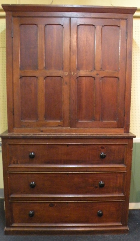A 19thC pine cupboard, the top with two panelled doors the base with three drawers on a plinth,