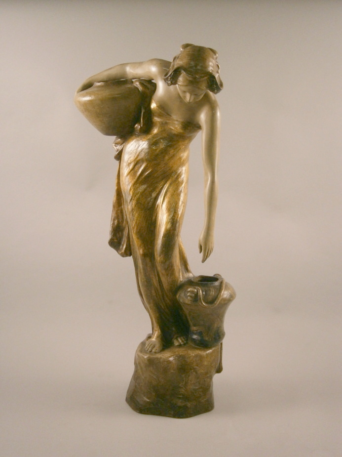 A late-early 20thC Goldscheider terracotta figure, of a water carrier, decorated in gilt, 64cm high.