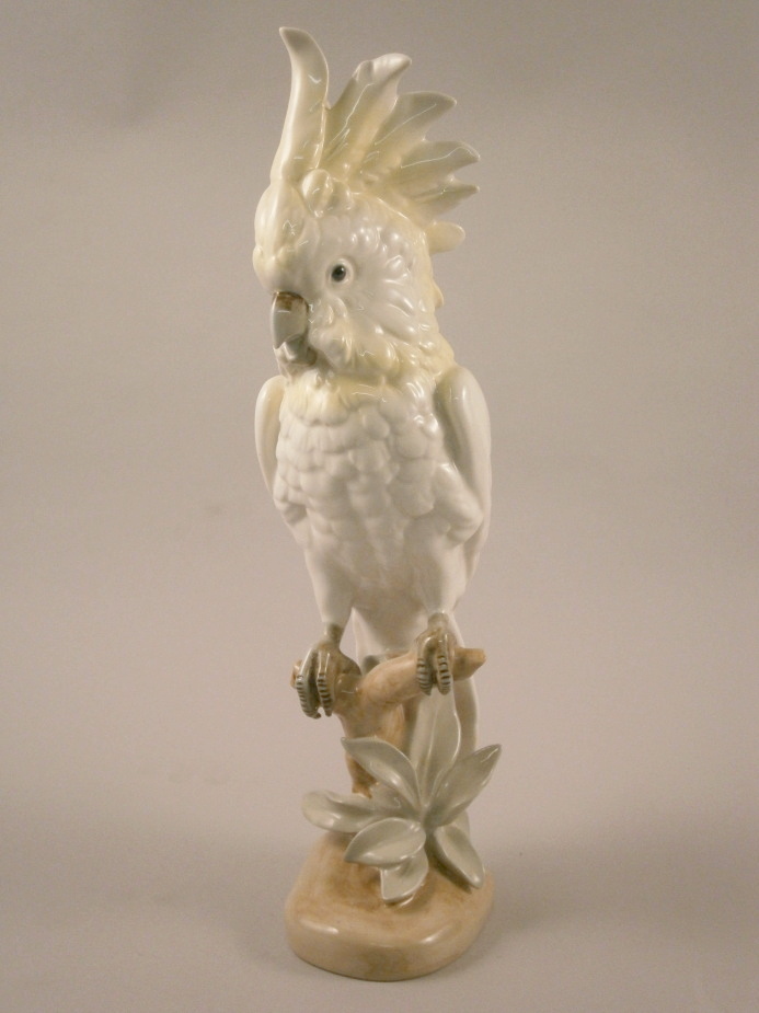 A large Royal Dux Parakeet, modelled on a branch, picked out in yellow, various marks to