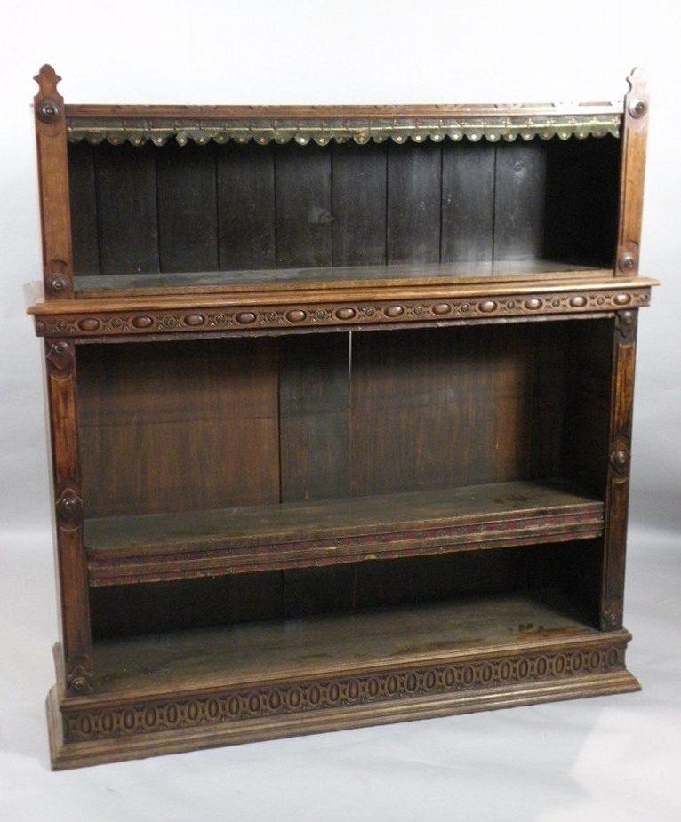 A Victorian oak bookcase, in two parts, the top applied with roundels, the base carved with ovals,