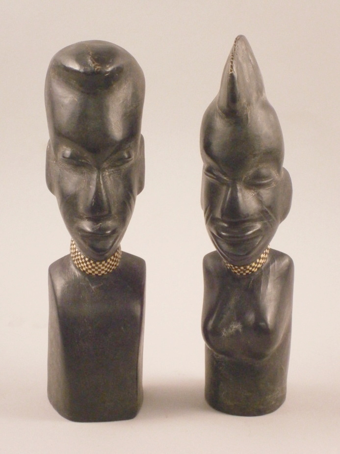 A pair of African leather and terracotta busts, each in the form of a man and a woman with a woven