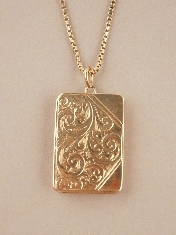 A rectangular locket on chain in 9ct gold, 7.7g.