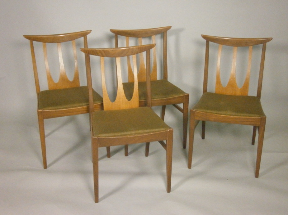 A set of four G-Plan type dining chairs, each with a rail back, a padded seat, bearing the label for