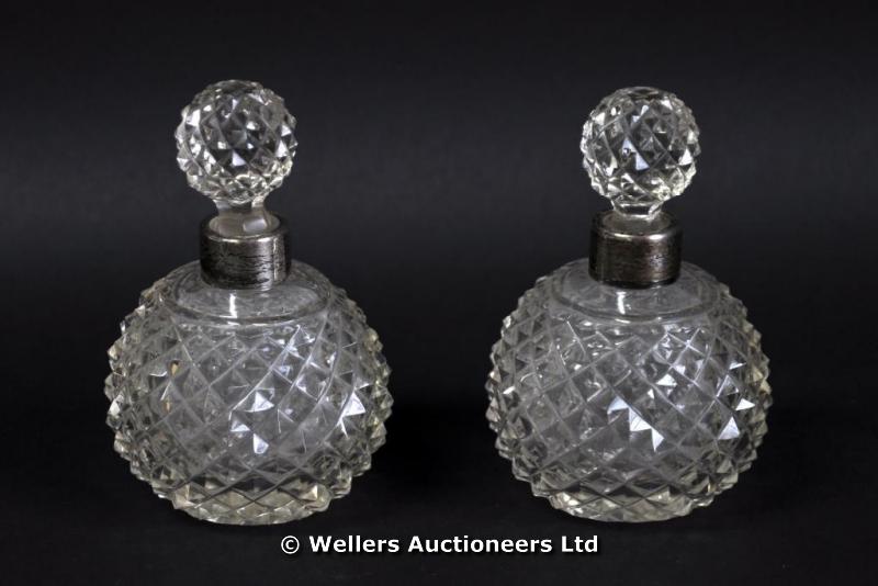 Two cut glass globular perfume bottles with silver mounts