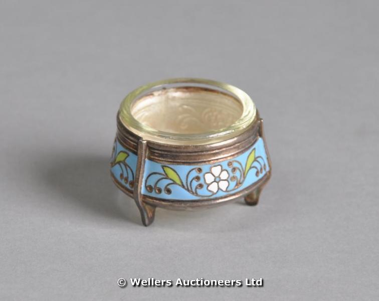 A circular white metal salt with enamel band of flower & leaves