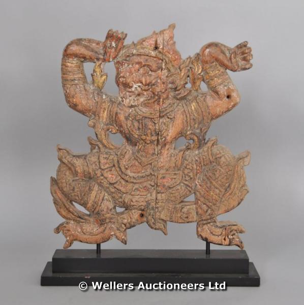 "A carved wood panel, possibly Balinese, of a dancing figure, on black display stand, 50cm high "