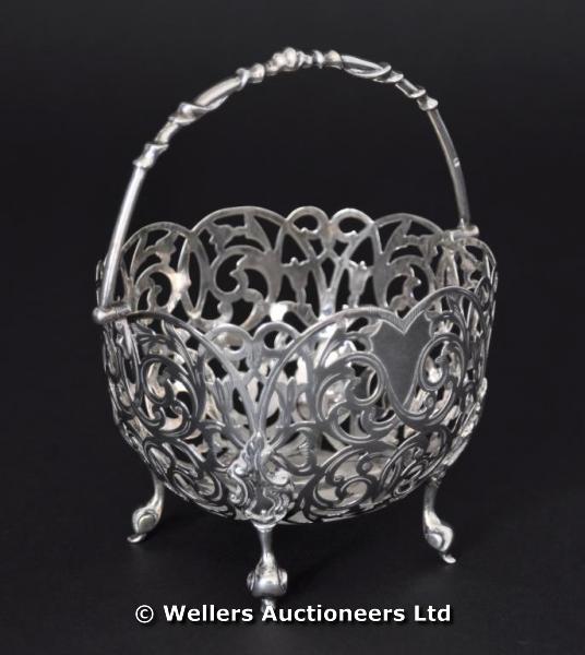 "A silver pierced basket with swing handle, circular on four feet, Birmingham 1859, makers mark of C