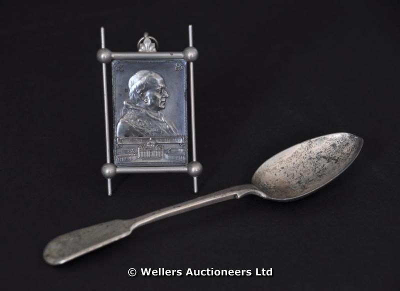 "A silver dessert spoon, Exeter 1862, makers mark JW & JW; and a white metal portrait of the Pontiff