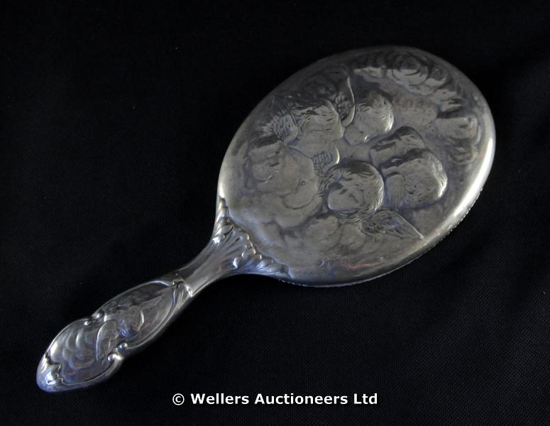 "A siver backed hand mirror, cherub design, London 1900"