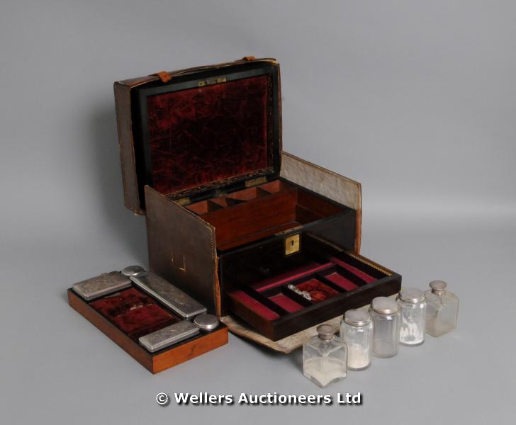 "A rosewood dressing box, the fitted interior with silver plated and glass bottles, leather outer