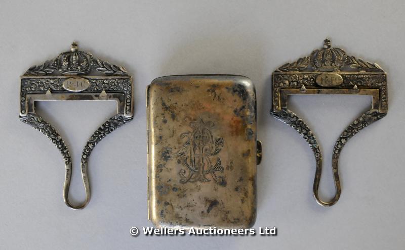 "A pair of silver plated bib and brace clips, initialed RJC; and a small silver cigarette case"