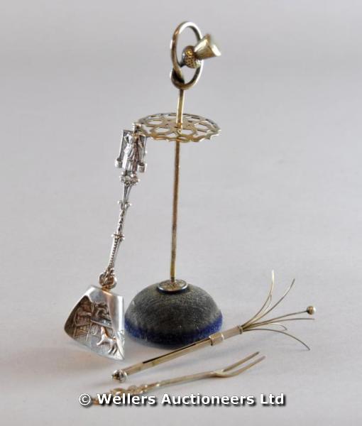 A Continental sugar scoop with embossed household scene; a silver swizzle stick; and Art Nouveau hat