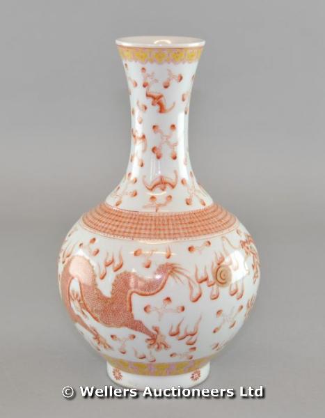 "A 20thC Chinese bottle vase in rouge de fer colours, decorated with two scaly dragons chasing the