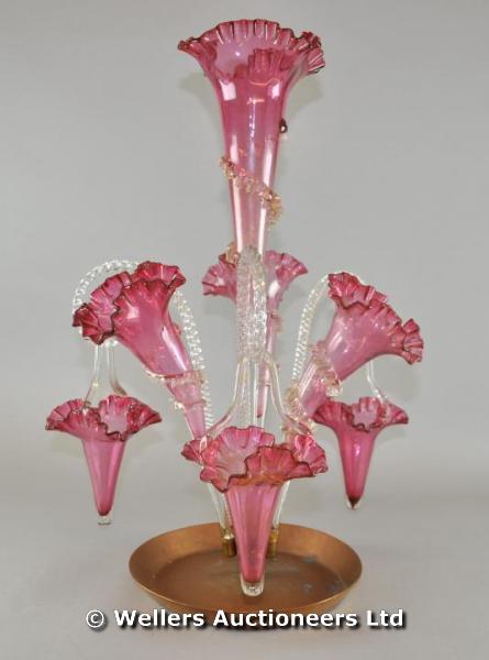 "A late Victorian cranberry epergne, frill trumpets & baskets set on later copper stand"