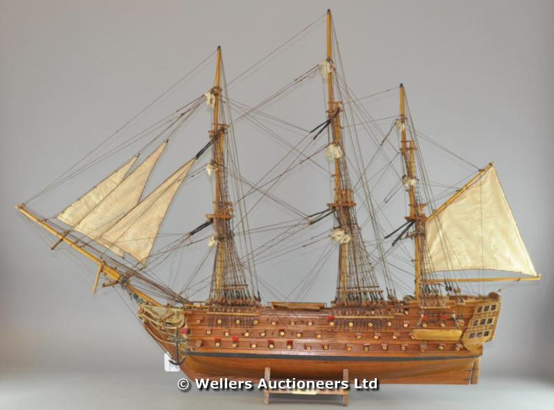 "A large wood model of HMS Victory, built 1765, with rigging and sails, on a wood stand, 104cm