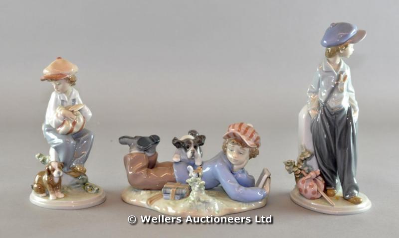 "A Lladro porcelain group of a boy lying down, resting on his arms and reading a book, with a dog
