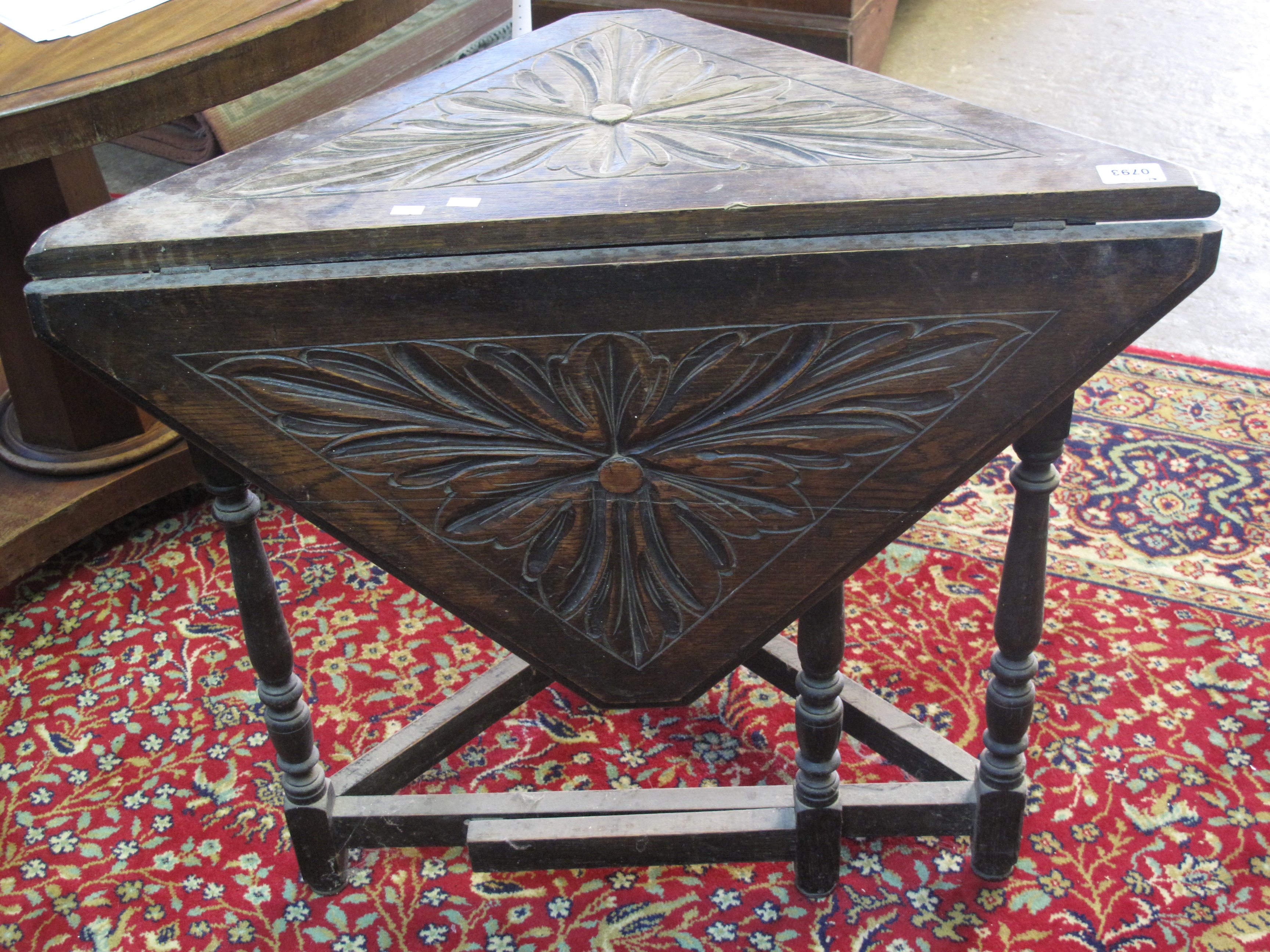 Early 20c stained oak drop leaf triangular side table with gate action underframe