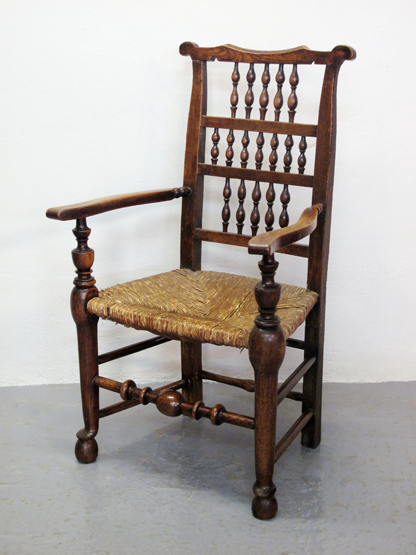 OAK AND ASH LANCASHIRE SPINDLE BACKED ARM CHAIR, with shaped cresting above three rows of baluster