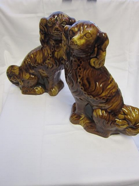 An unusual near pair of treacle glazed Staffordshire spaniels, circa 1880, each modelled in seated p