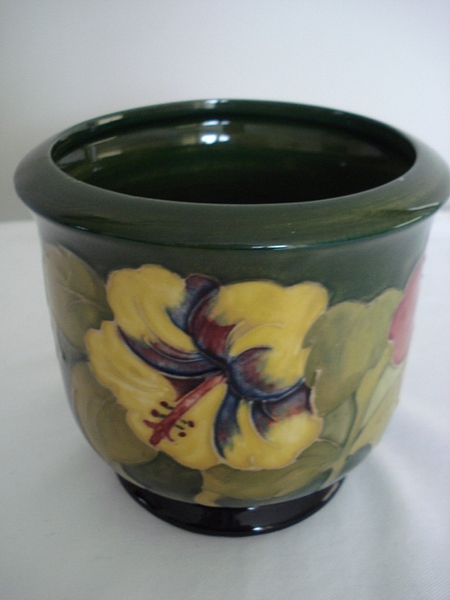 A Walter Moorcroft Hibiscus Jardiniere, of form to pattern on green ground, impressed mark, and