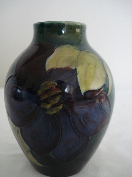 A Moorcroft `Clematis flambe glazed pottery vase, the shaded green and blue ground tube lined with a