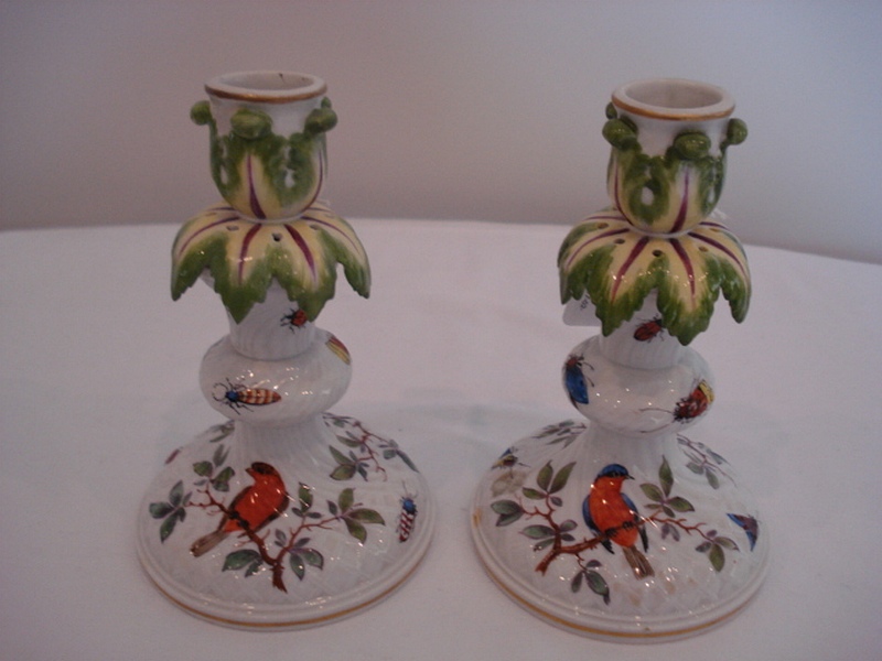A pair of Meissen candlesticks, Circa 1860, each hand painted in vibrant colours of insects with