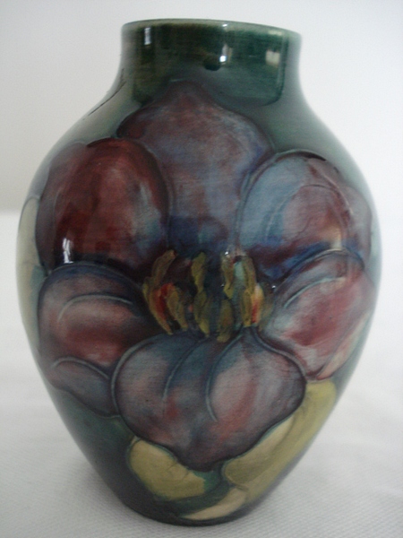 A Moorcroft `Clematis flambe glazed pottery vase, the shaded green and blue ground tube lined with