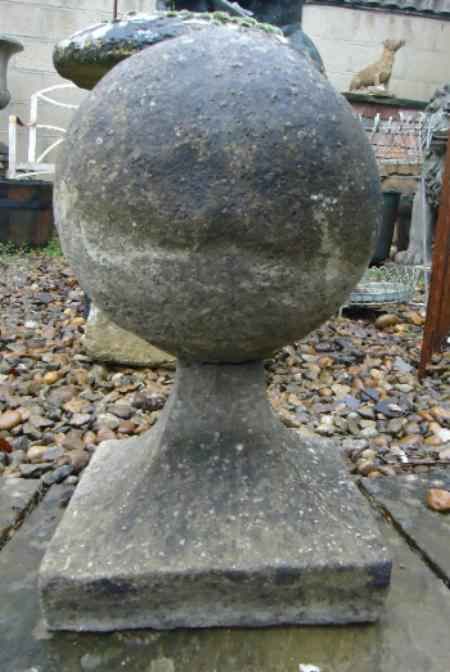A reclaimed damaged weathered reproduction stone ball on plinth 508mm (20"") high × 305mm (12"")