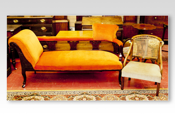 A late Edwardian mahogany sofa and a cane backed polished elbow chair